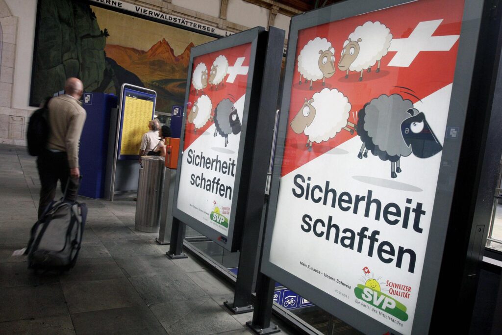 Affiche de campagne de l’UDC montrant des moutons blancs expulsant un mouton noir du territoire suisse (2007)